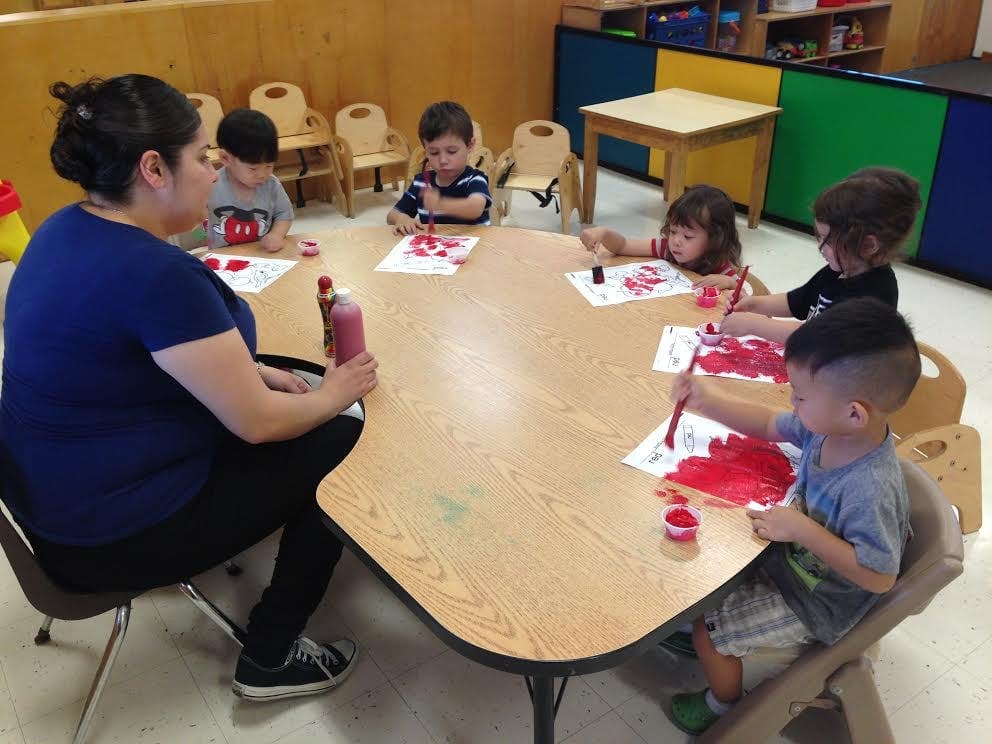 Adult and children painting at a table