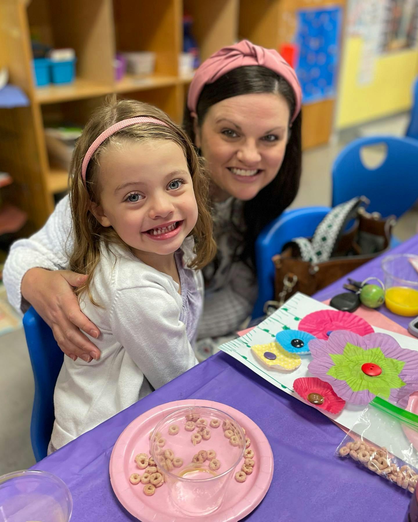 Adult and child sitting at a table with craft supplies
