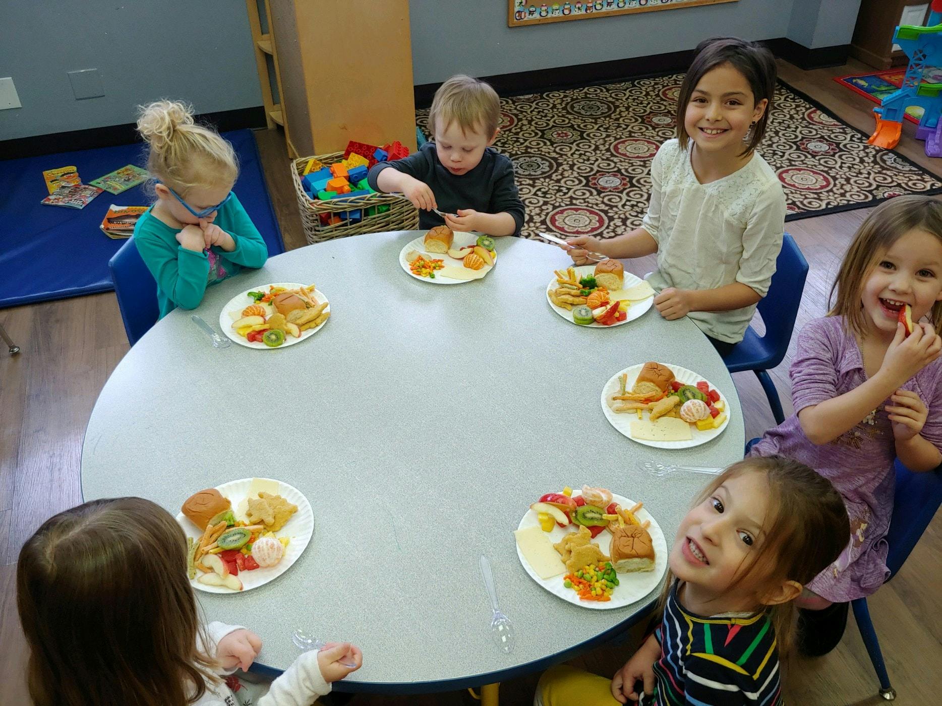 Children eating meals at a round table