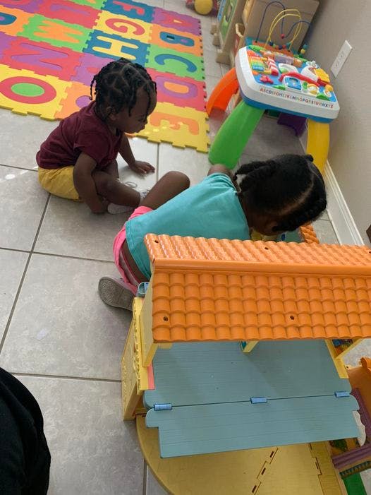 Two children playing on the floor with toys