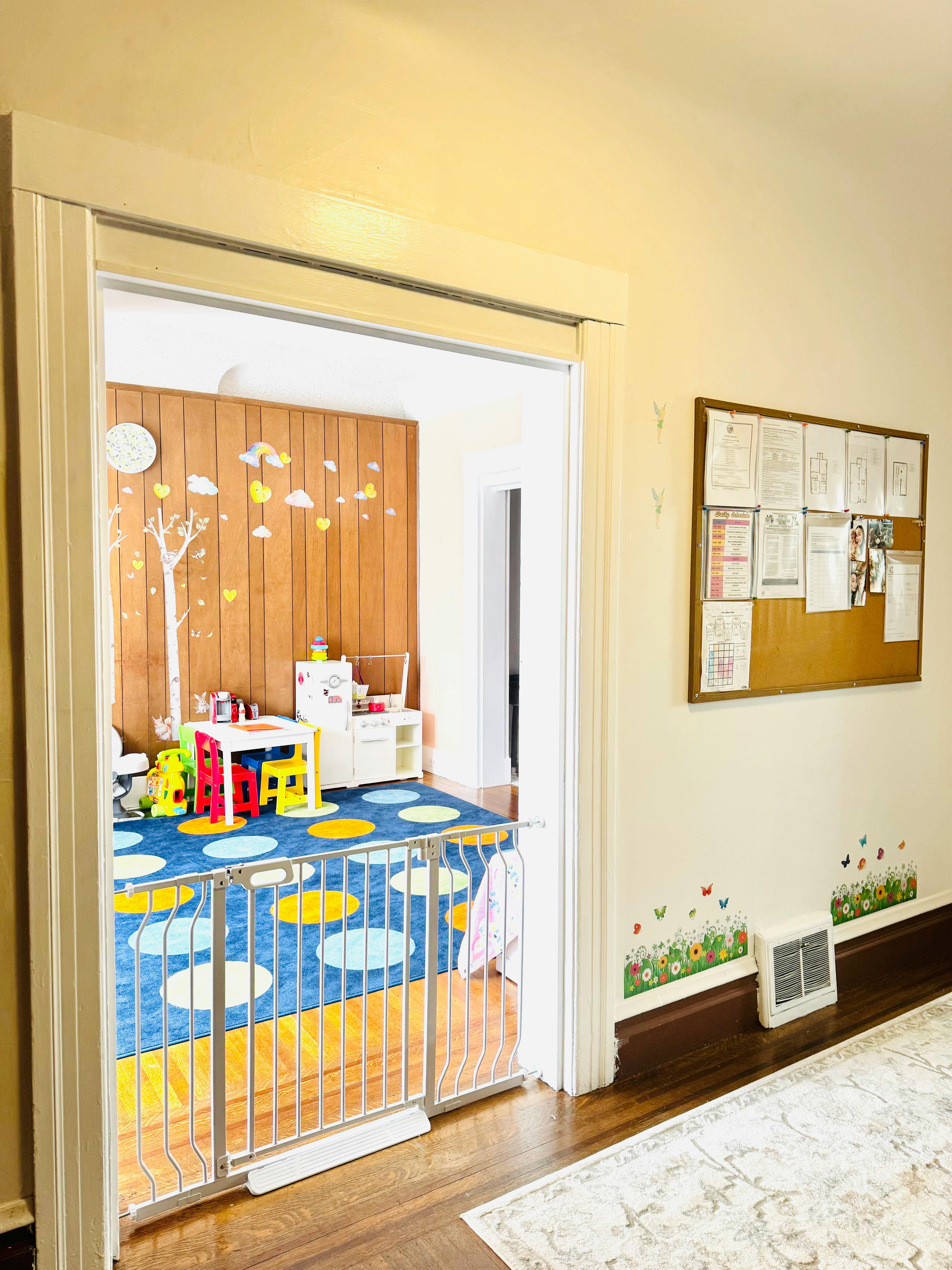 Playroom with a child safety gate, small table and chairs, and toy kitchen