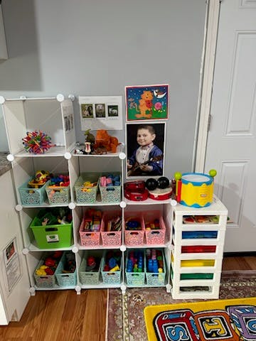 White modular shelving unit filled with colorful bins of toys