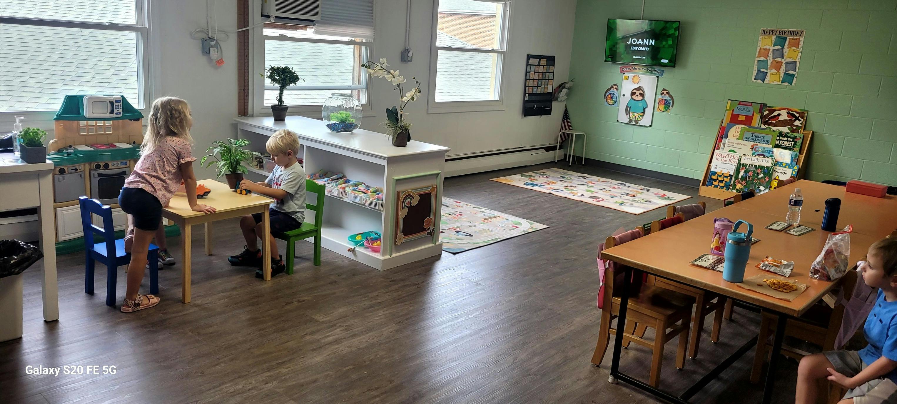 Two children at a small table in a classroom