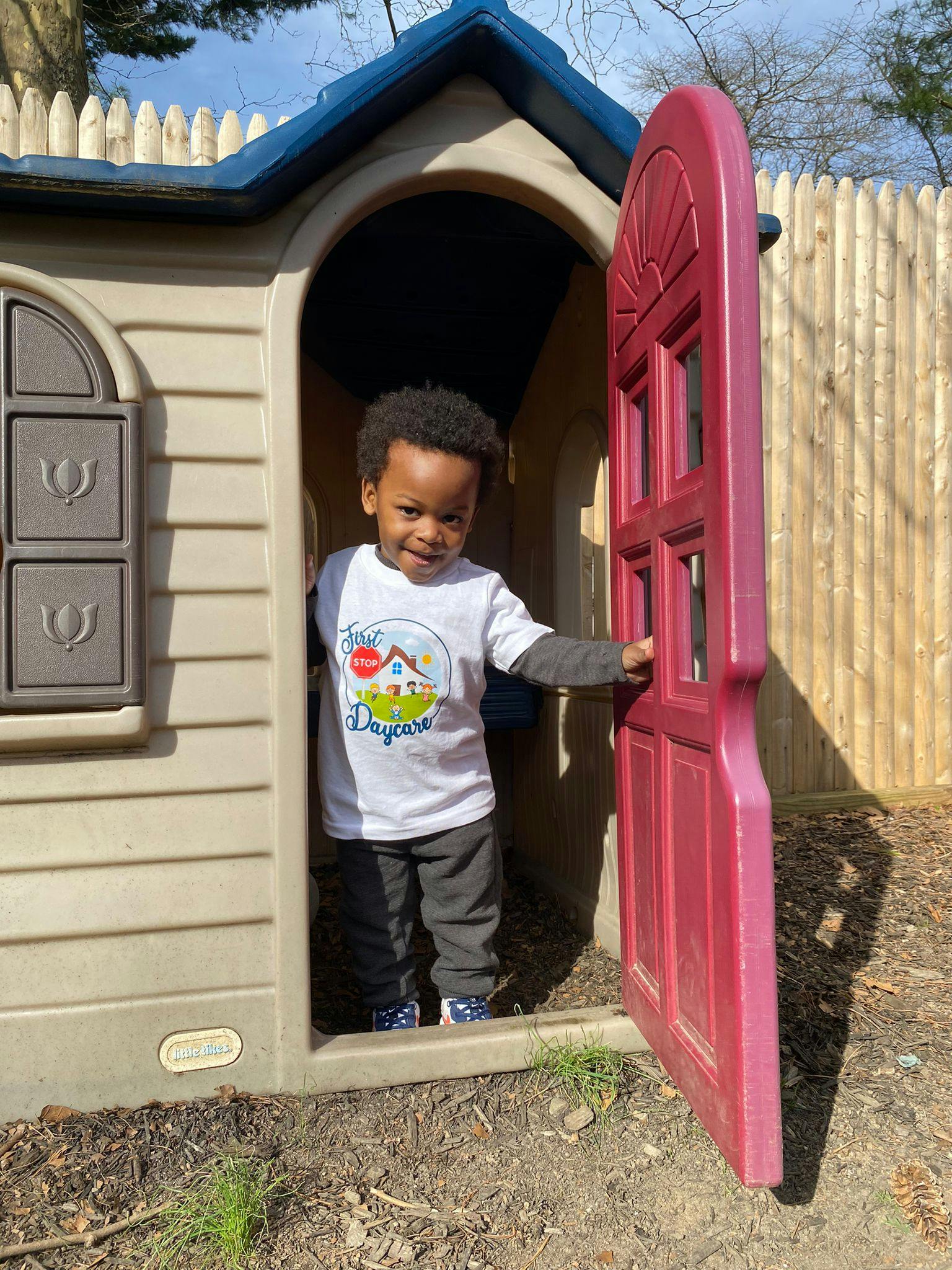 Child standing in a playhouse doorway