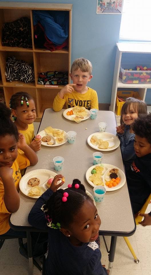 Children sitting at a table with plates of food