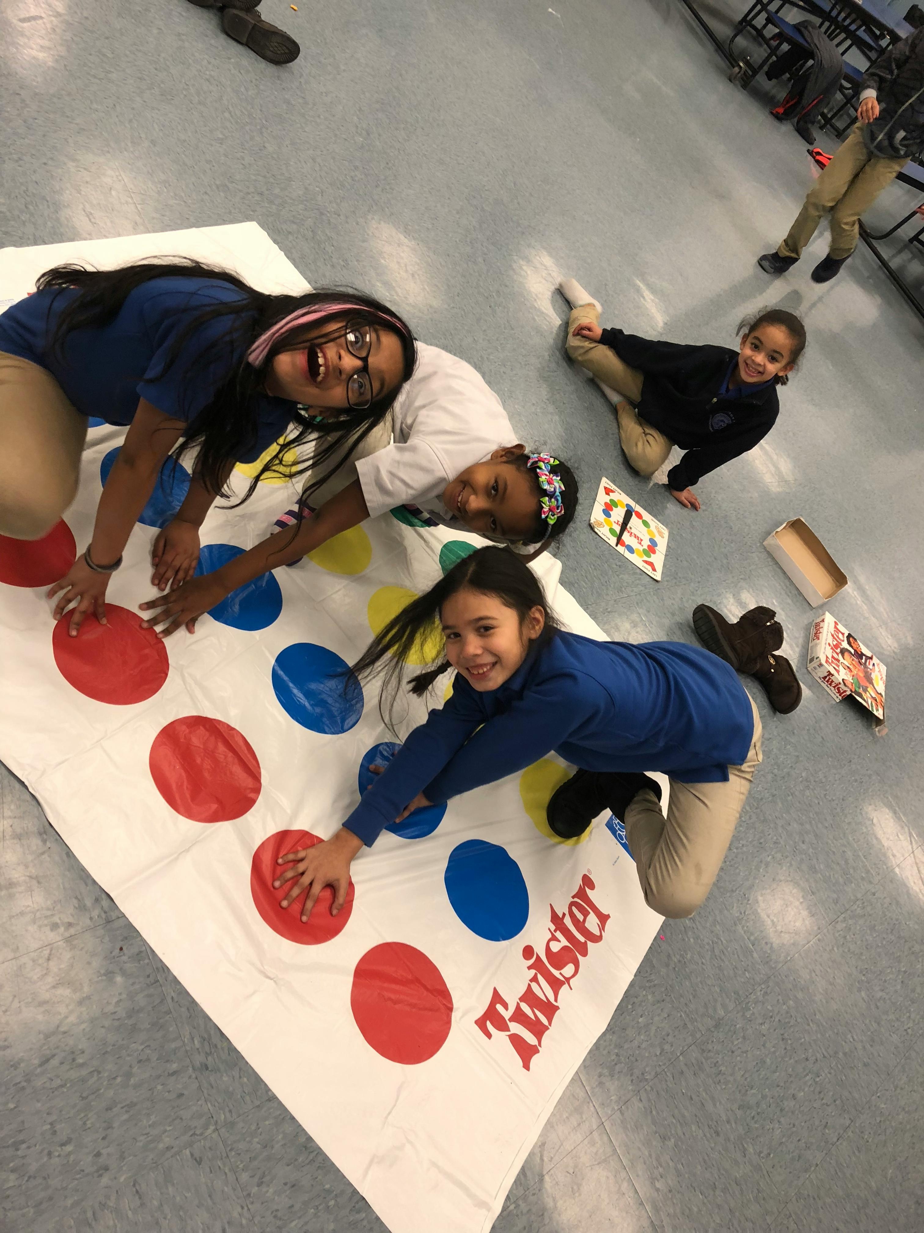 Three children playing Twister on the floor