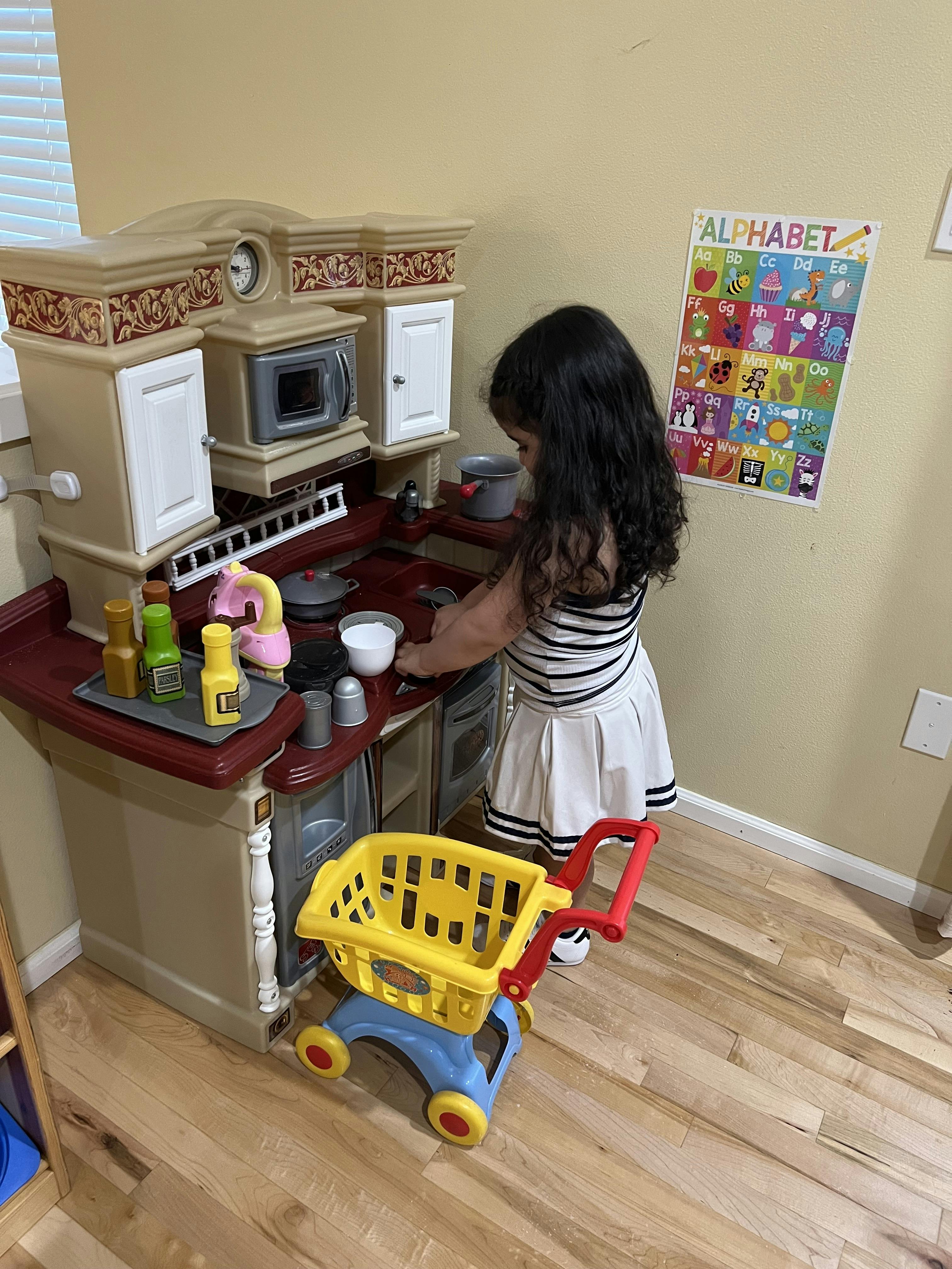 Child playing with a toy kitchen set