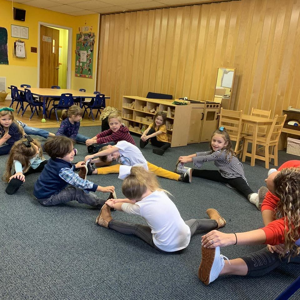 Children stretching on the floor in a classroom