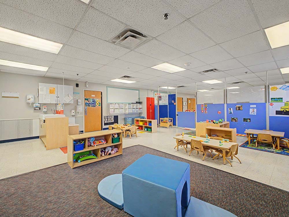 Empty colorful children's classroom with small tables and chairs