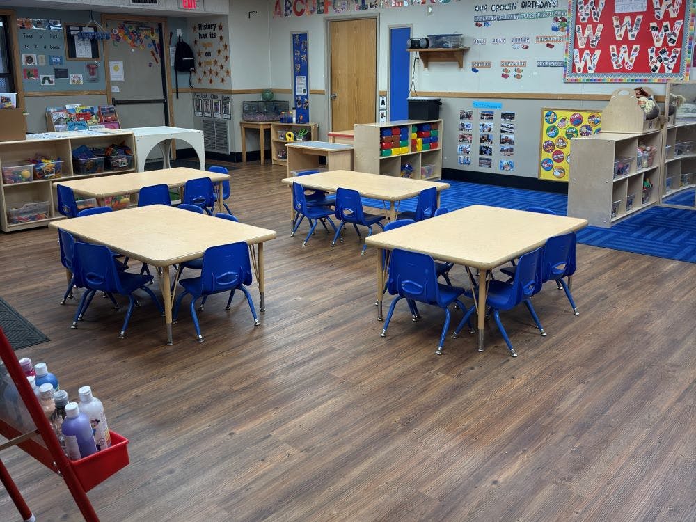 Empty classroom with small tables and blue chairs