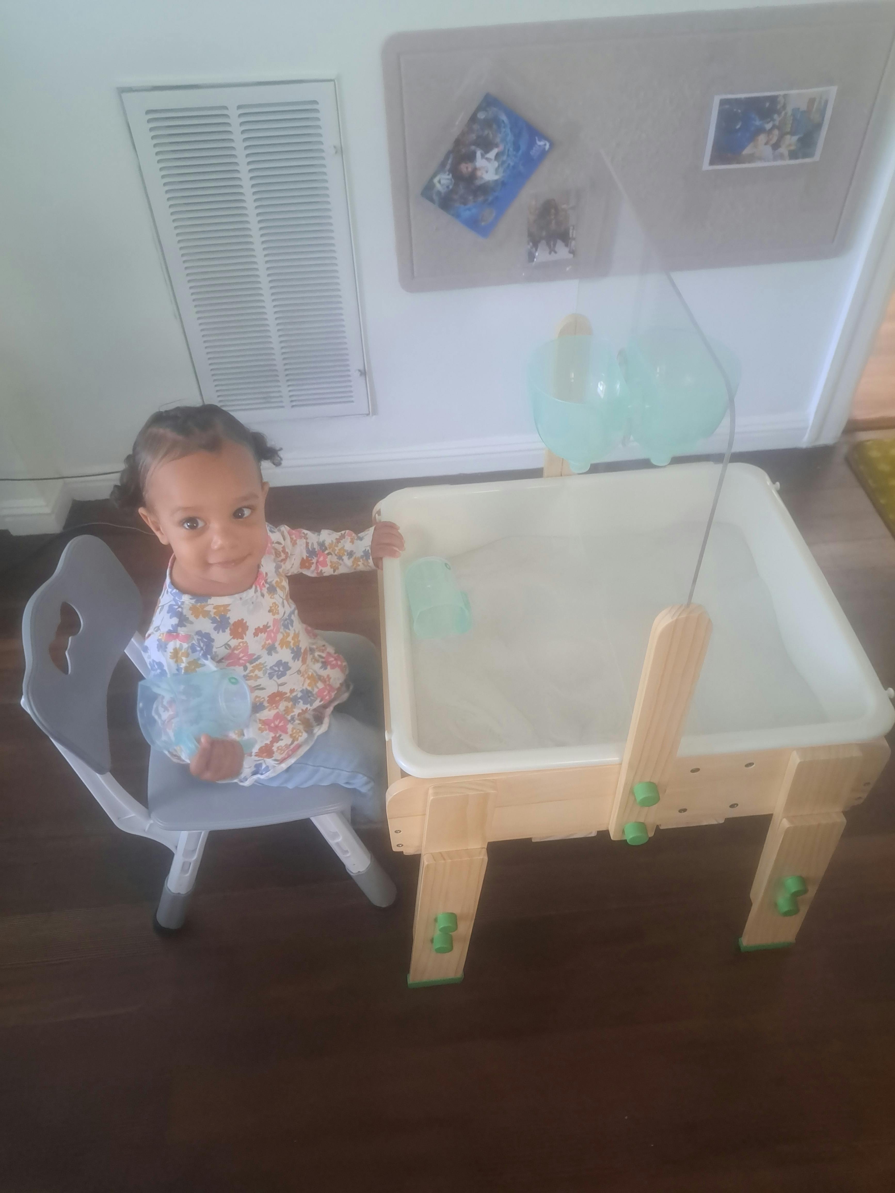 Child sitting at a table with a clear bin