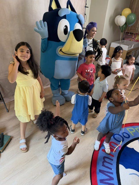 A mascot character posing with a group of children
