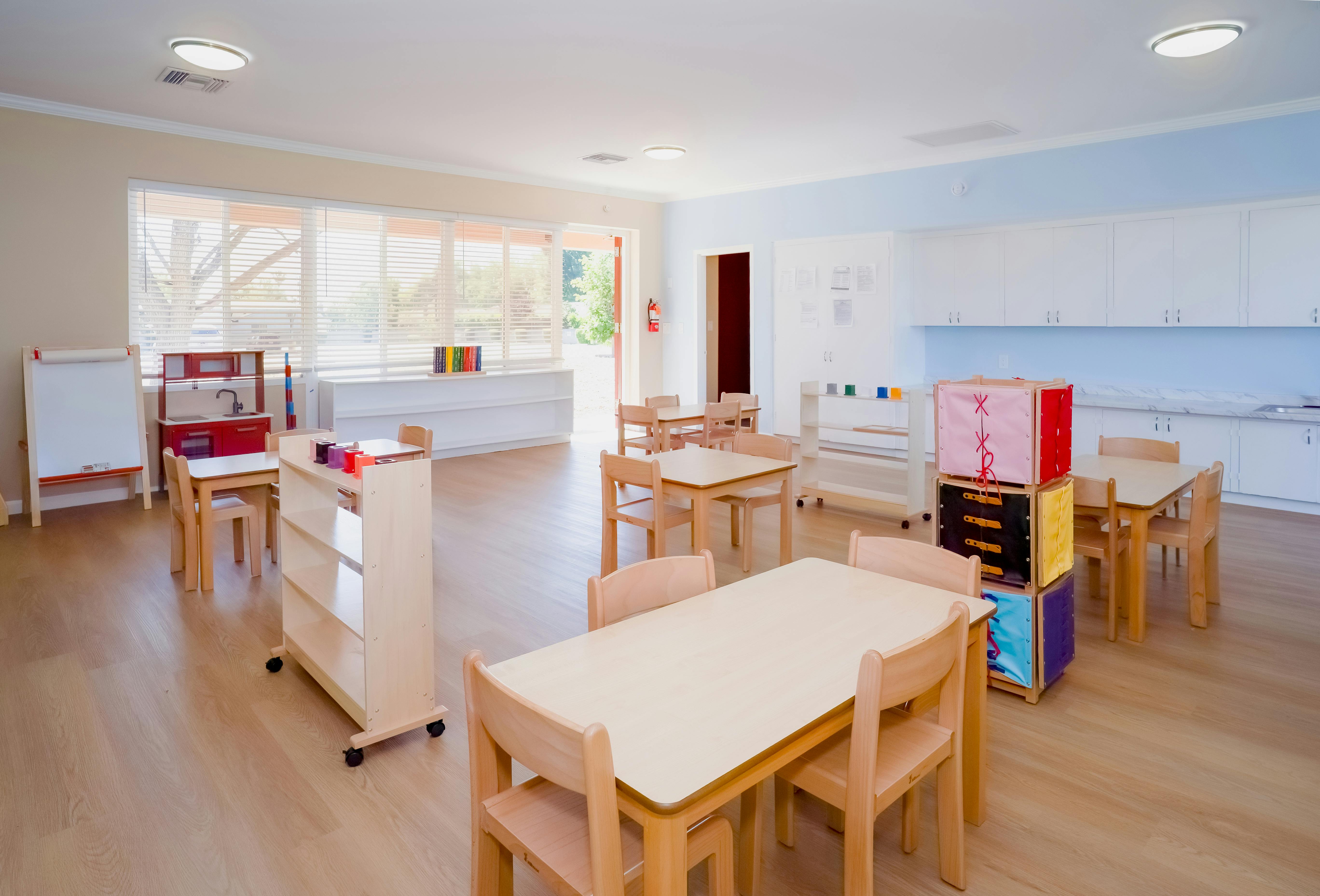 Empty classroom with small tables and chairs