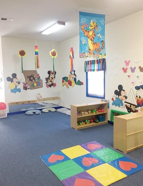 Playroom with character decorations, shelves, and a colorful mat