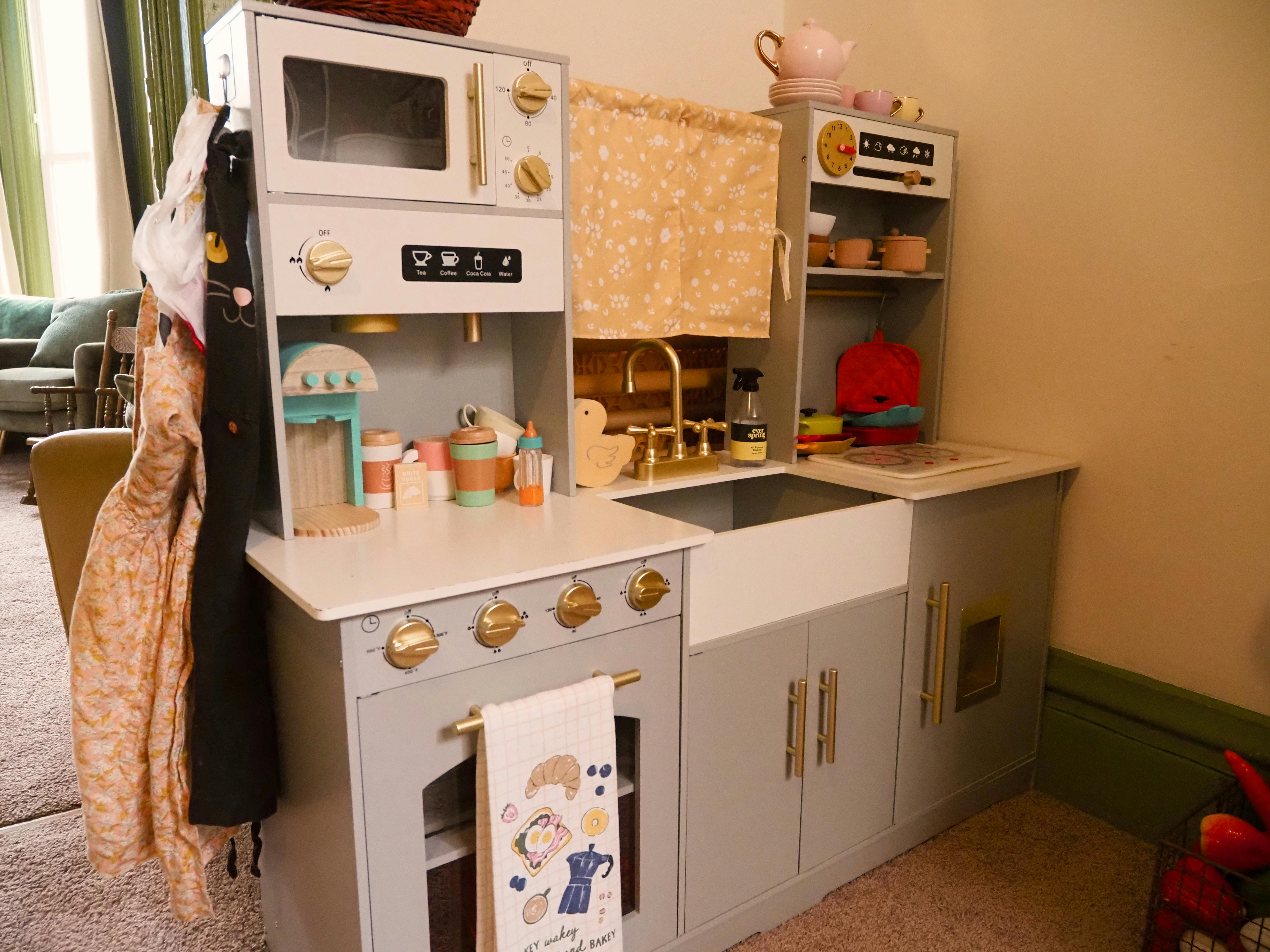 Toy kitchen set with play accessories and hanging towels
