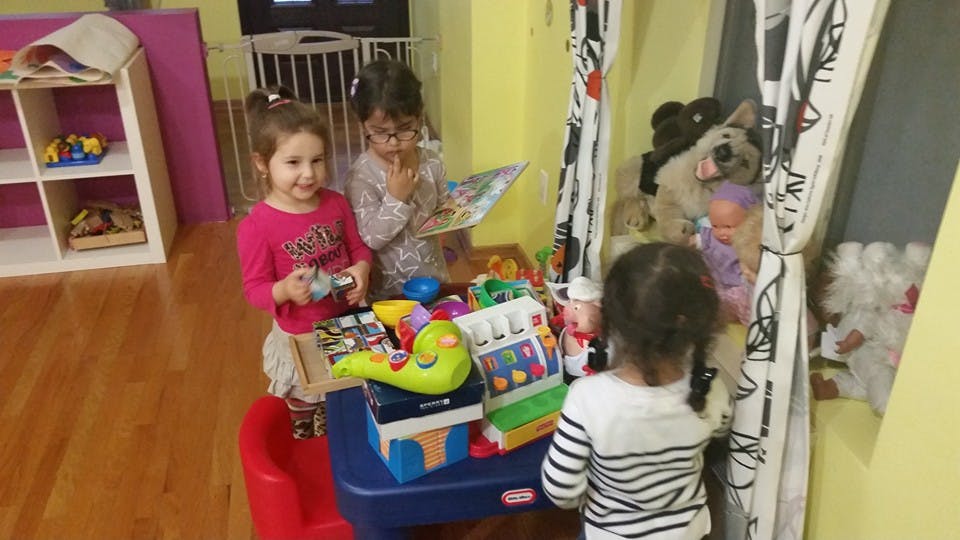 Three children playing with toys in a room