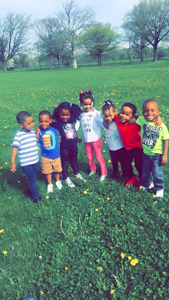 Group of children standing together in a grassy field