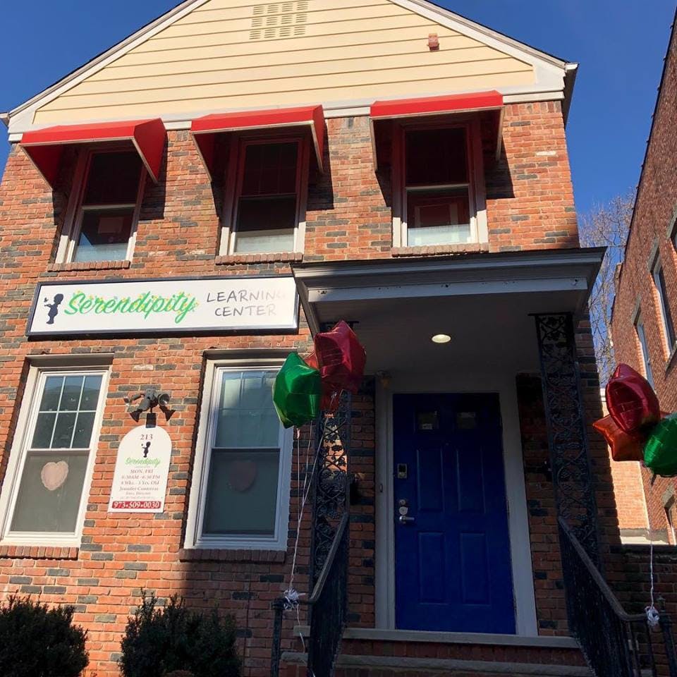 Brick building with red awnings and a sign that reads "Serendipity Learning Center"