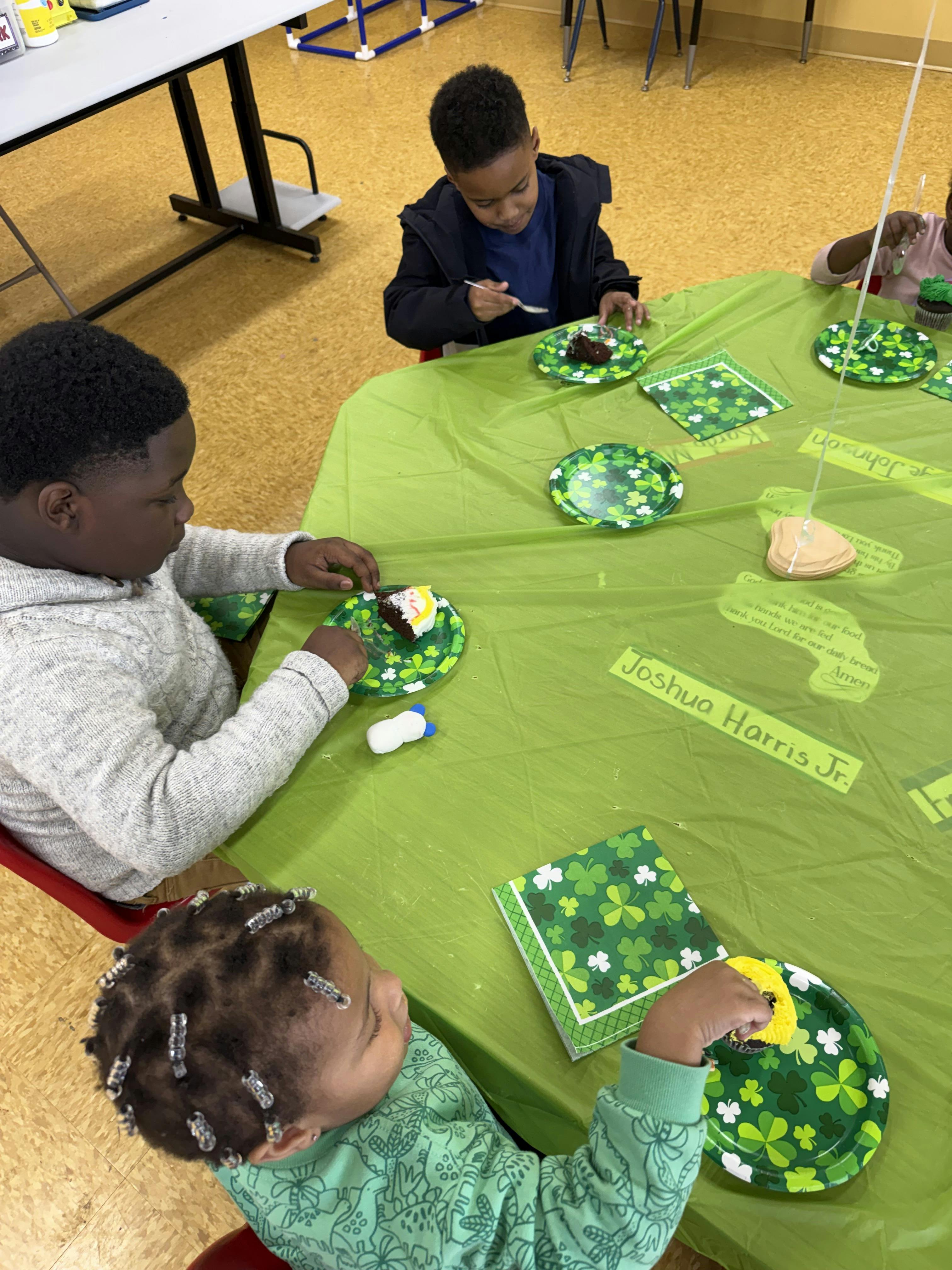 children eating cake at a table with shamrock plates