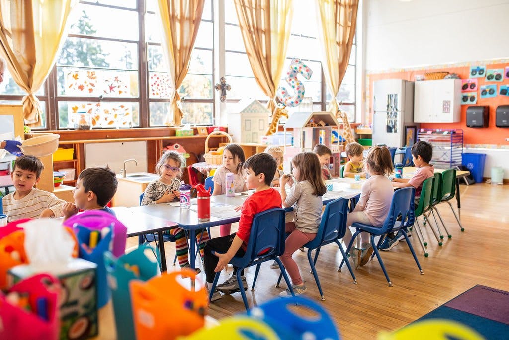 Children sitting at tables in a classroom