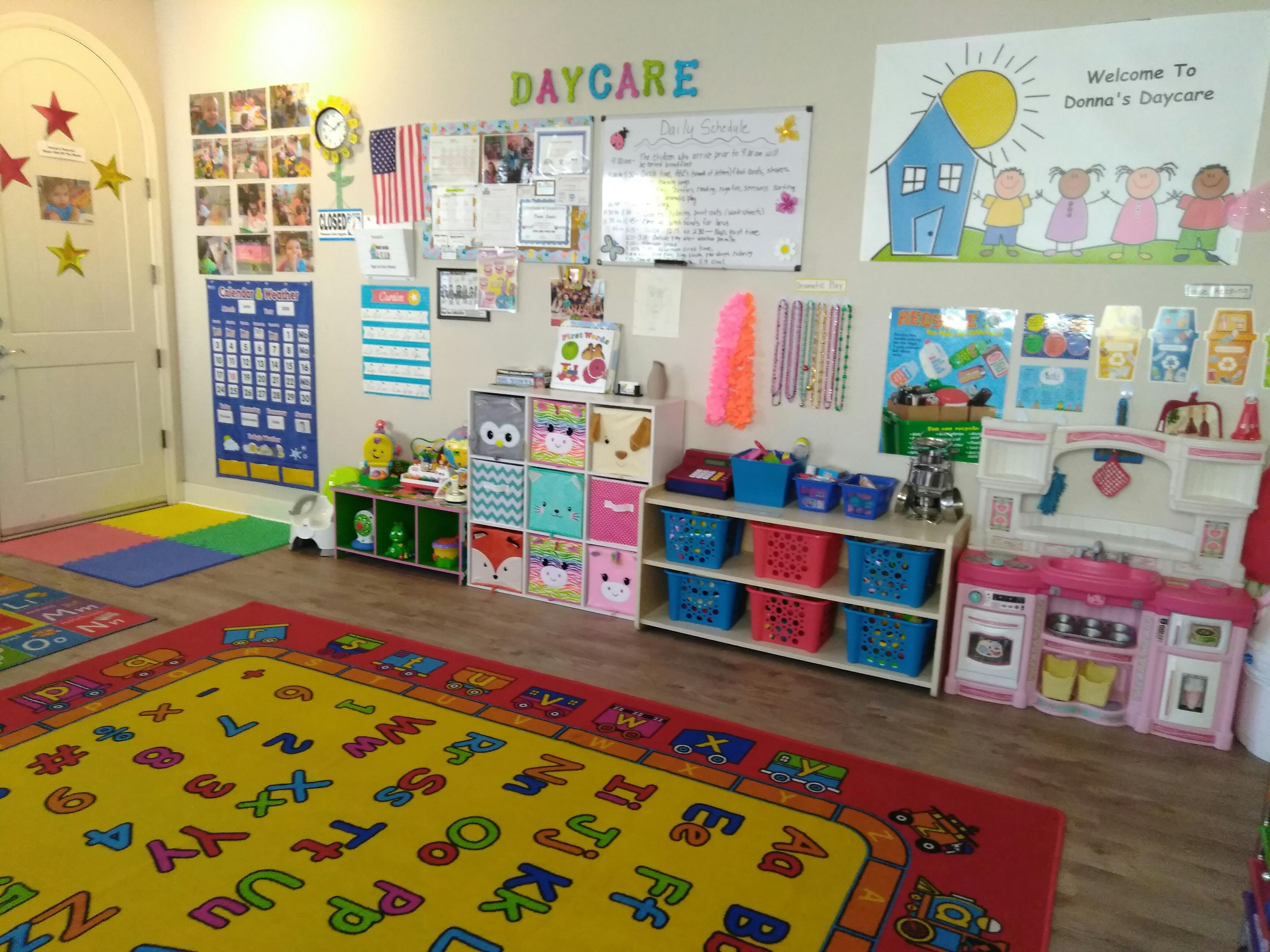 Daycare classroom with colorful rugs, shelves, and wall decorations