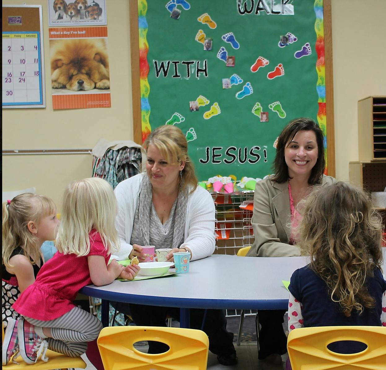 Two people and three children sitting at a table