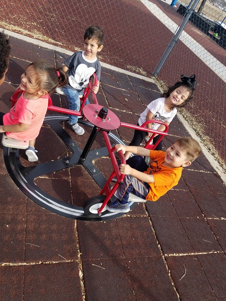 Four children on a playground merry-go-round