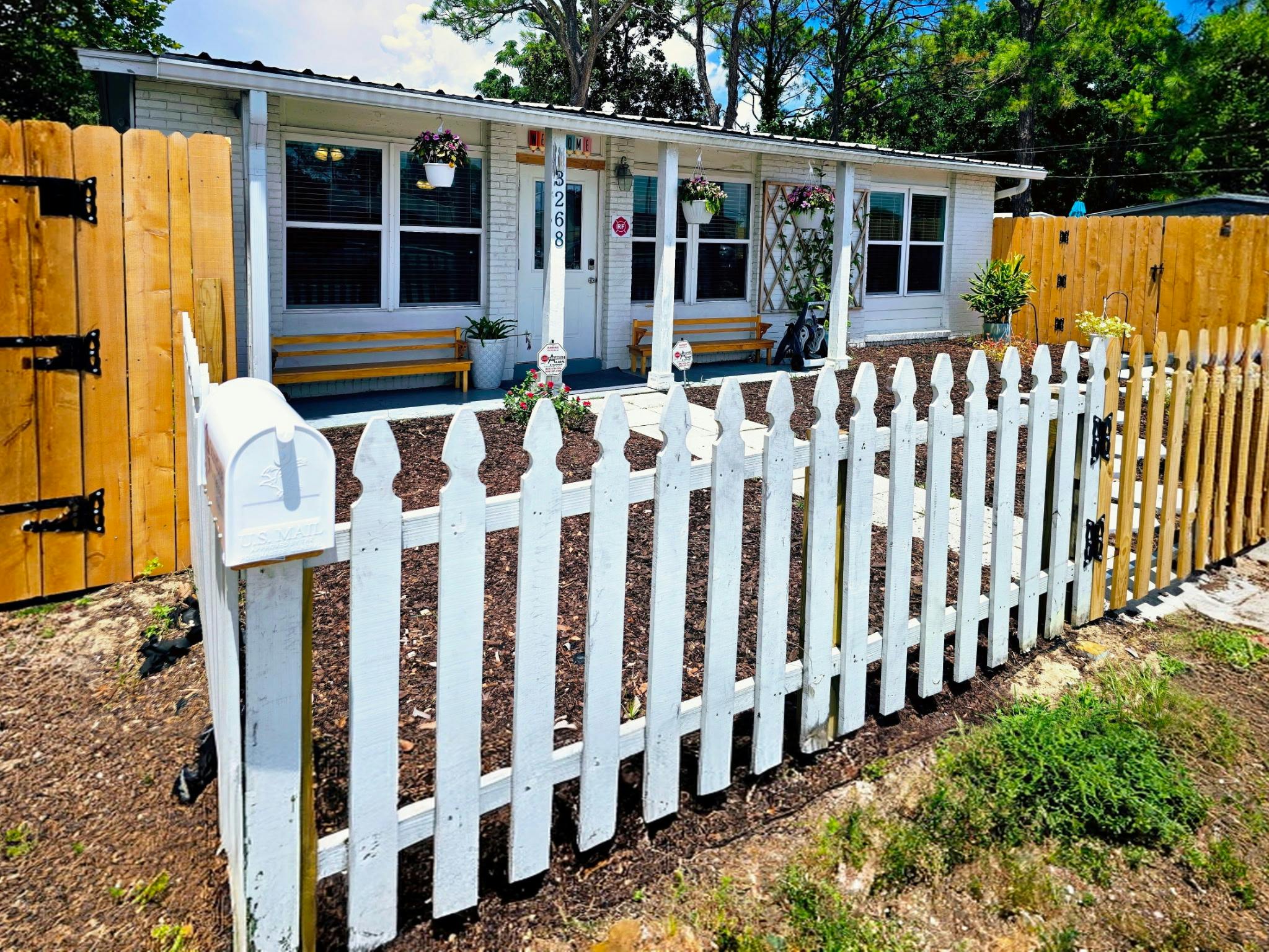 White house with a porch and a white picket fence