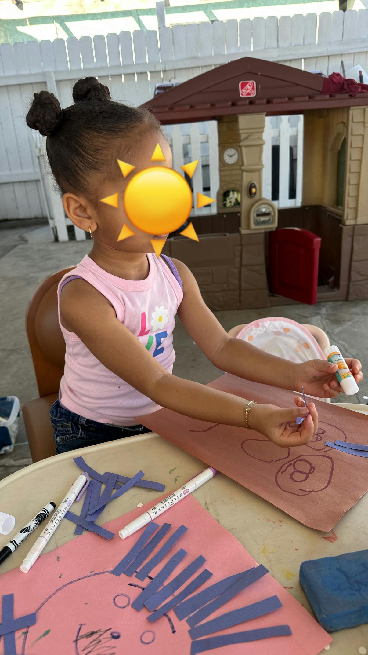 Child crafting with paper strips and glue on a table