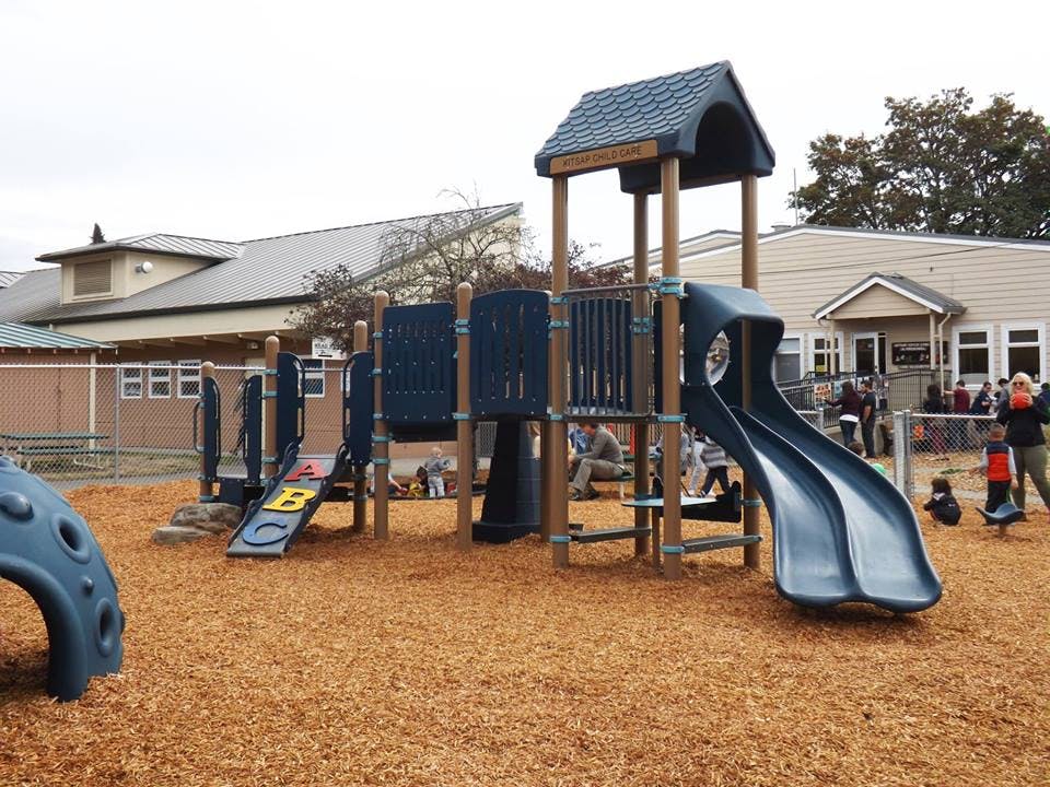 Playground structure with slides and climbing elements on wood chips