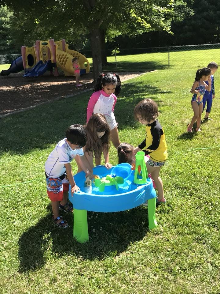 Children playing at a water table outdoors