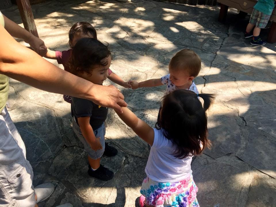 Adult and children holding hands in a circle