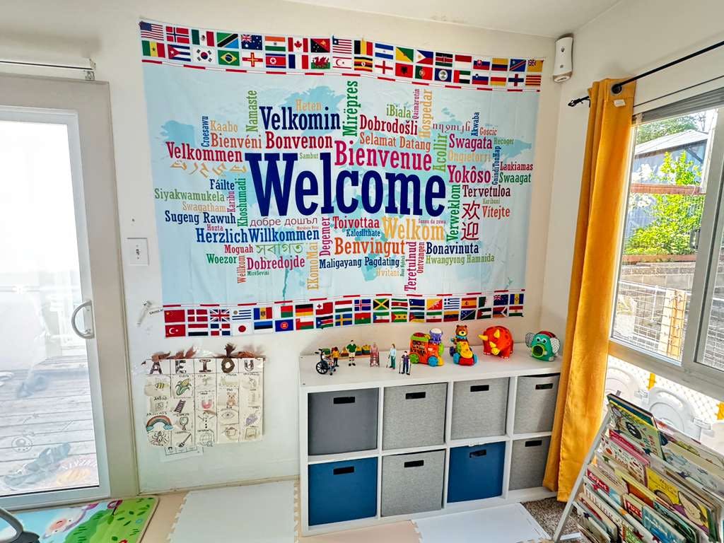 Wall decoration featuring the word Welcome in many languages and international flags