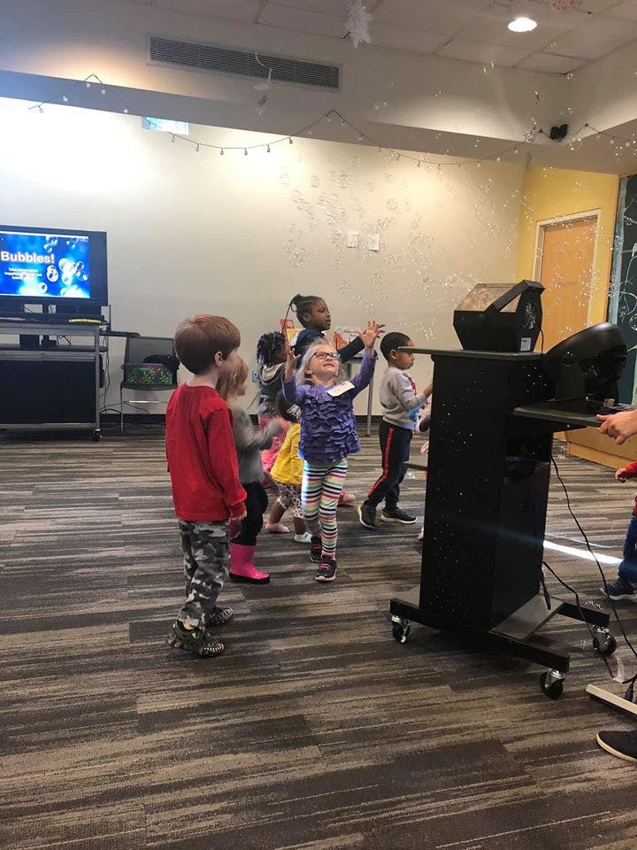 Children playing with bubbles indoors