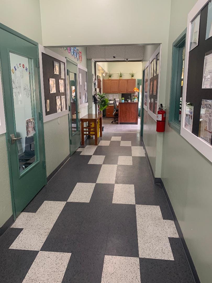 Hallway with checkered floor leading to an office area