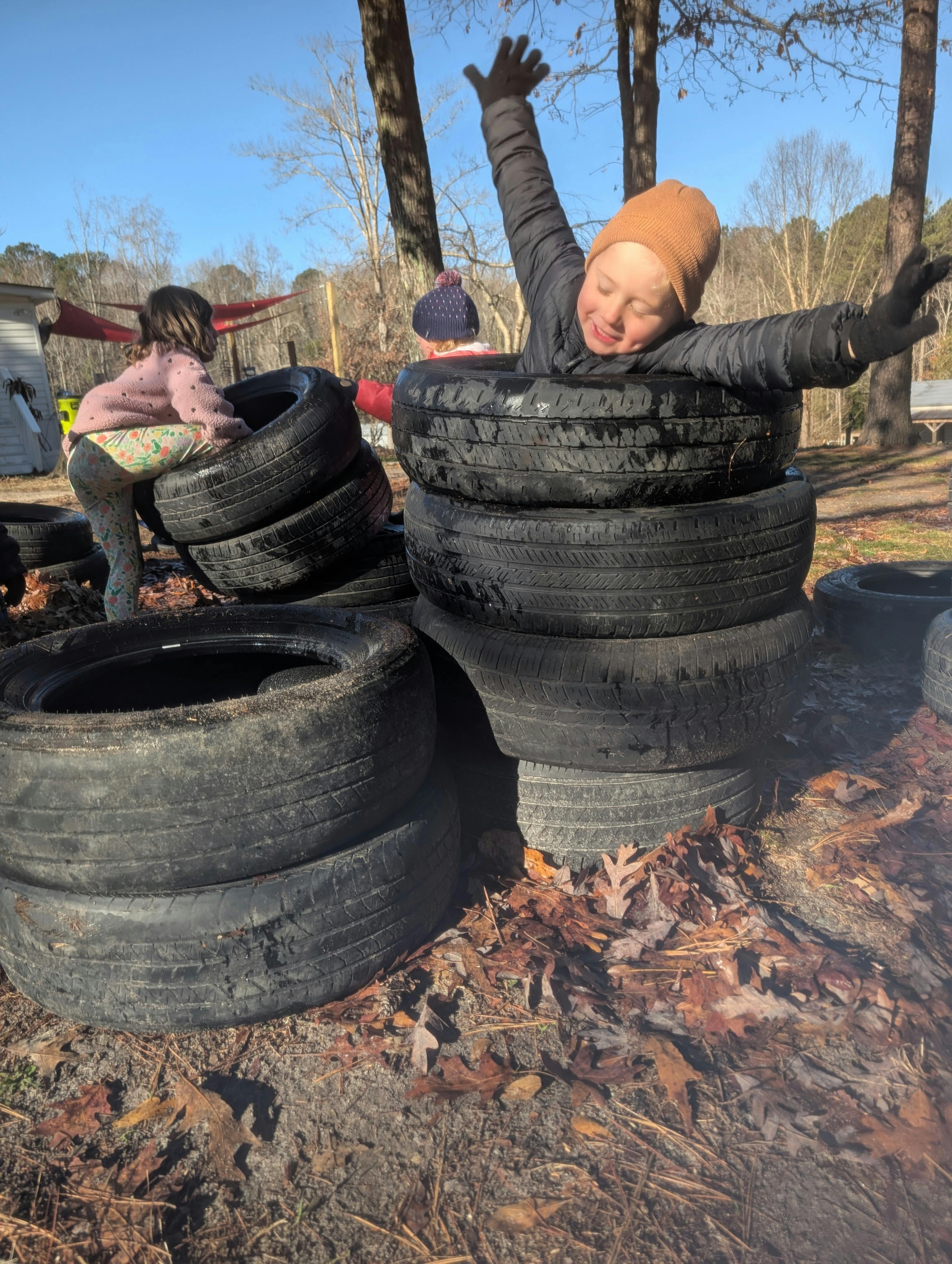 Children playing on a stack of tires outdoors