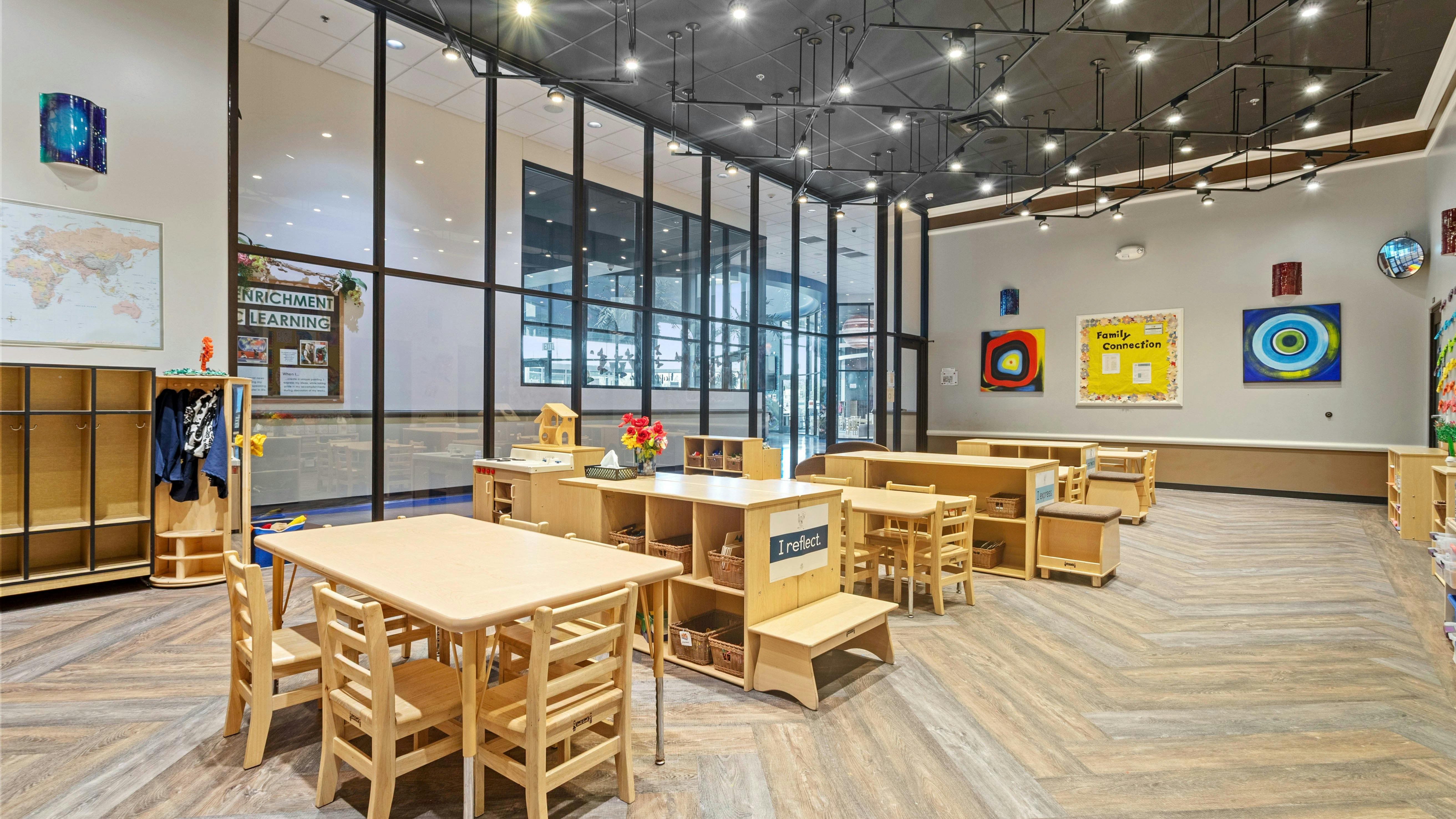 Empty classroom with small wooden tables and chairs