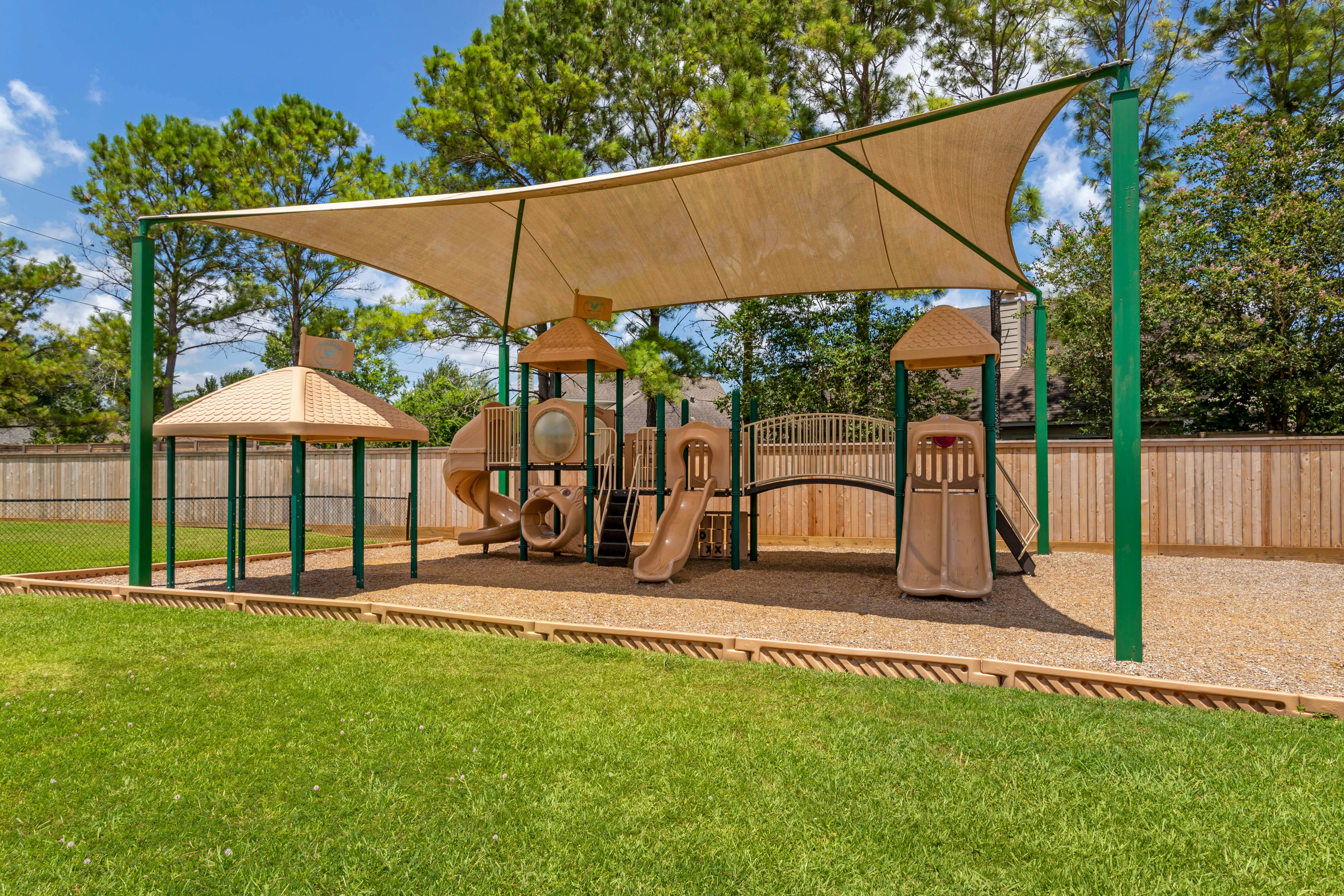 Empty playground with a sand-colored sun shade