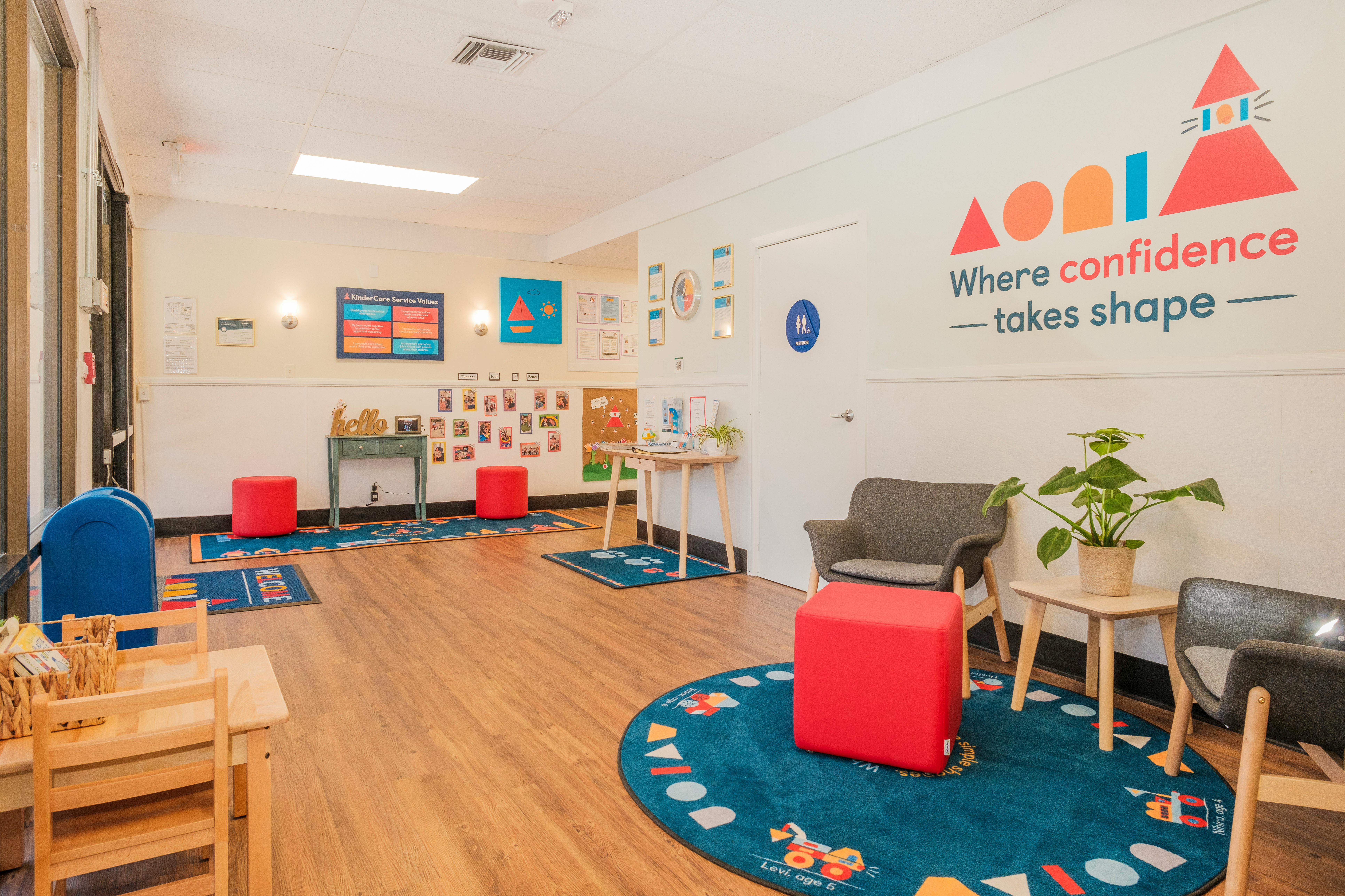 Room with various children's play areas, small chairs and tables, and colorful rugs
