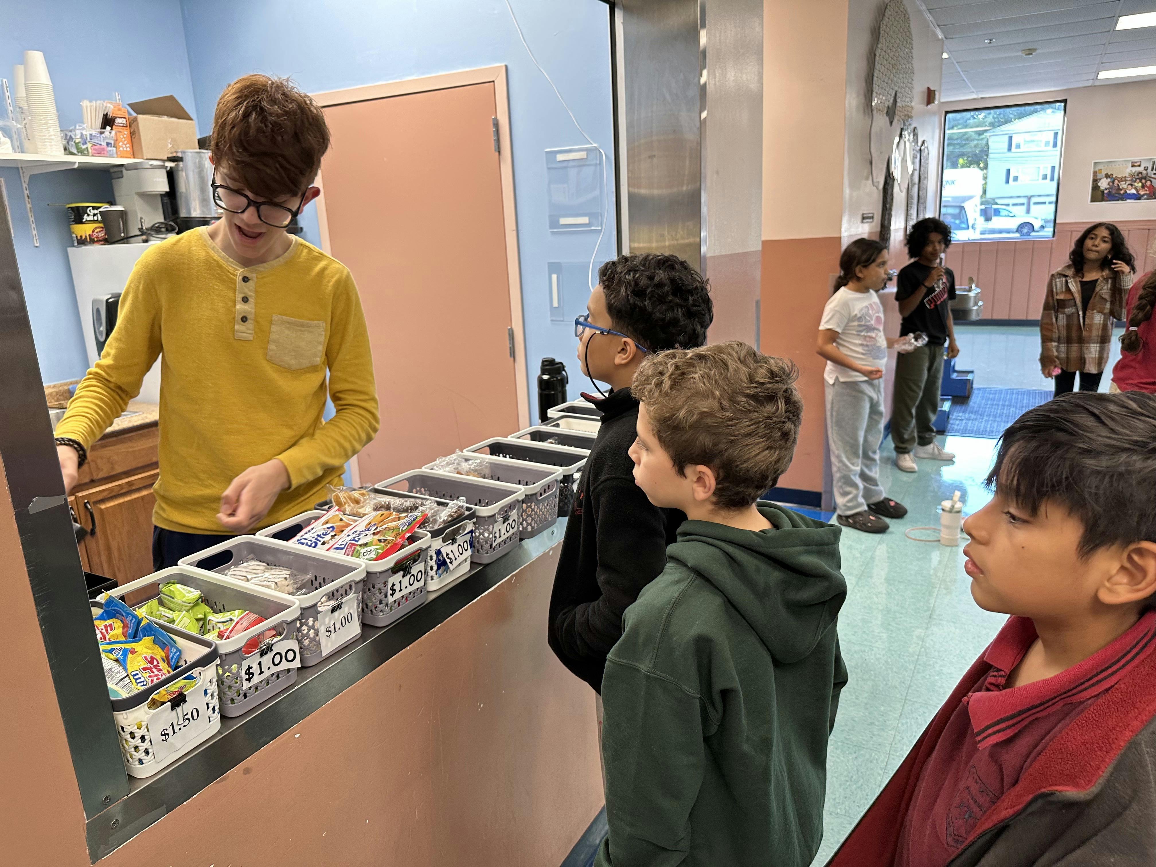 A person serving snacks to children at a concession stand