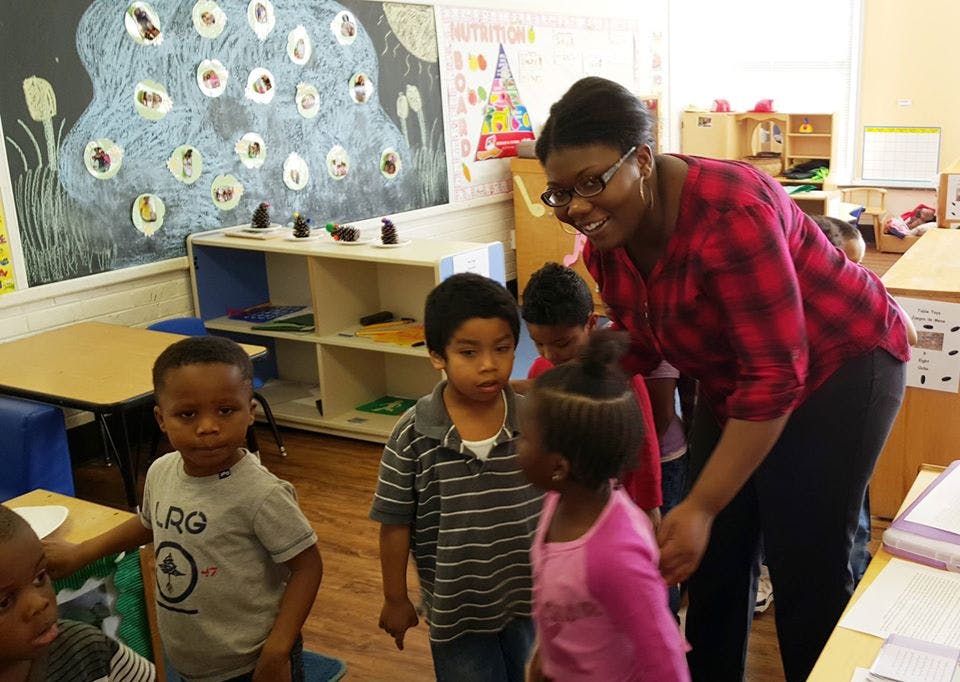 Adult person interacting with children in a classroom