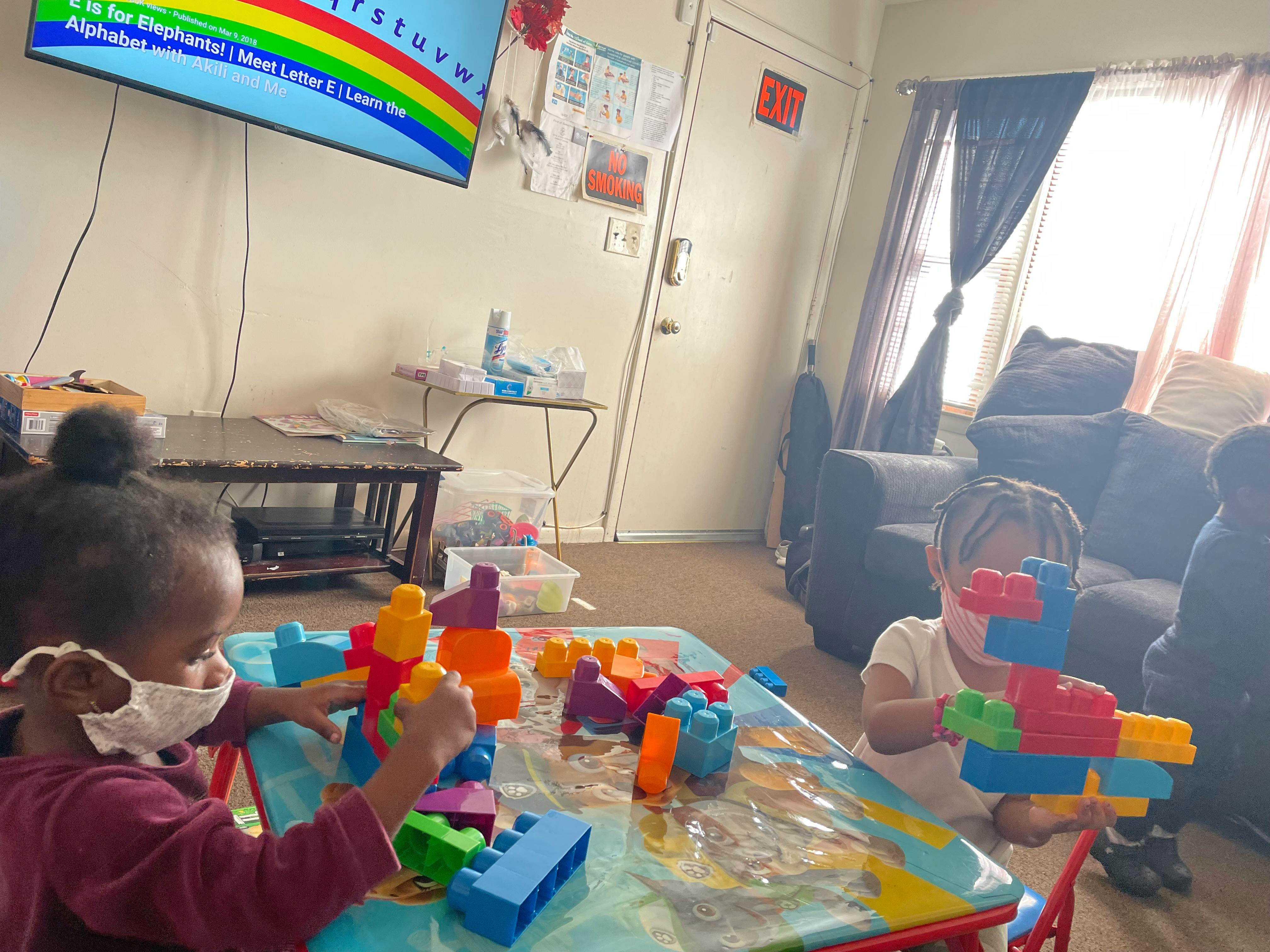 Two children playing with colorful building blocks at a table