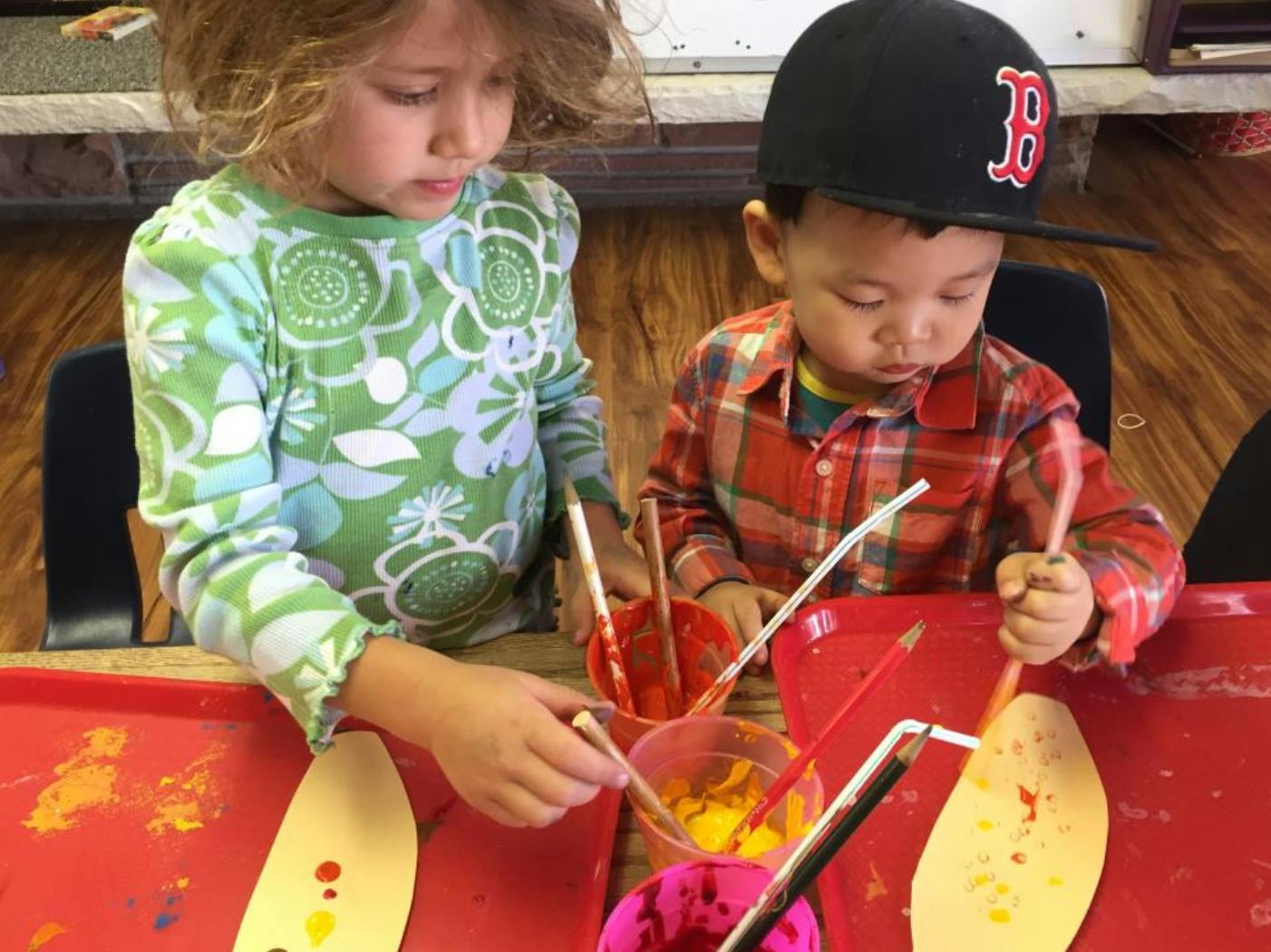 Two children painting at a table