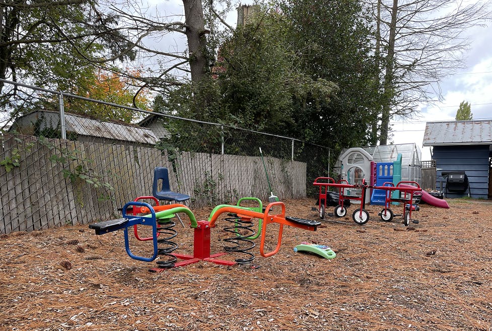 Playground with spring riders, tricycles, and a slide