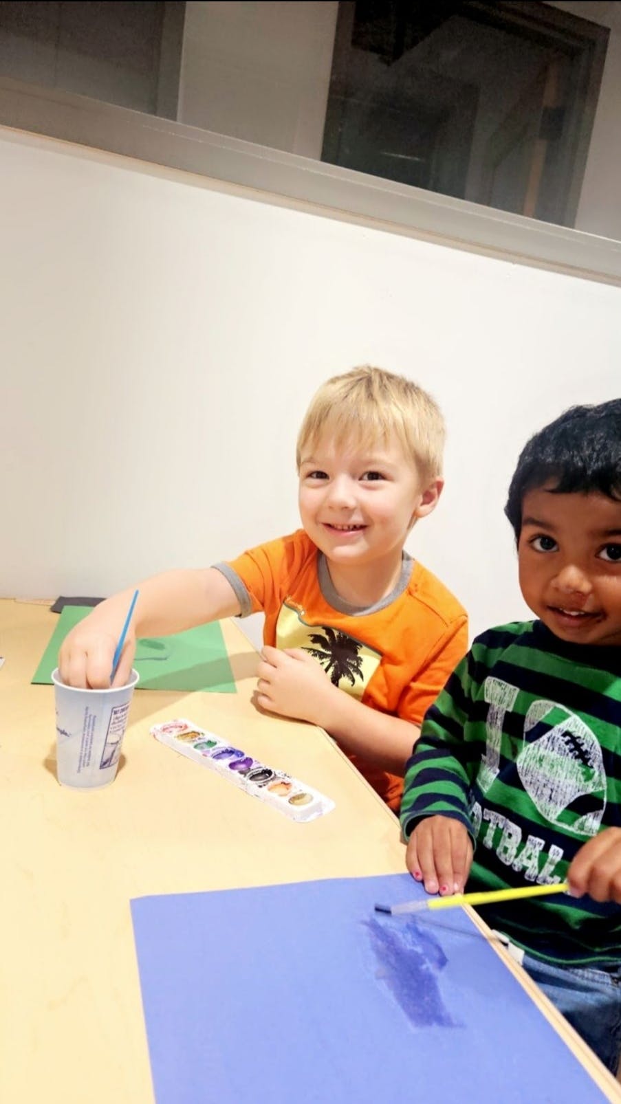 Two children painting at a table