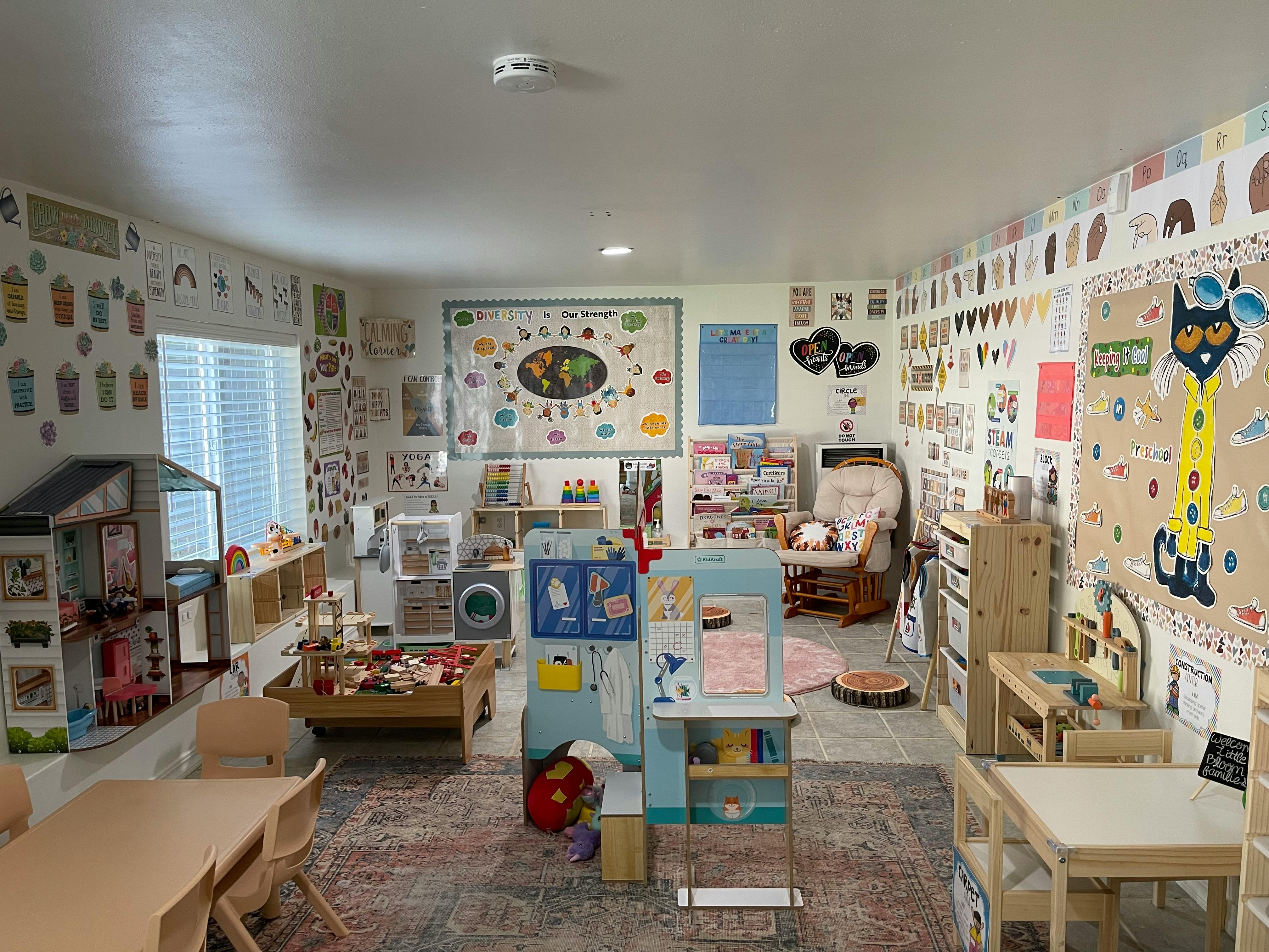 A classroom with various play areas and learning materials