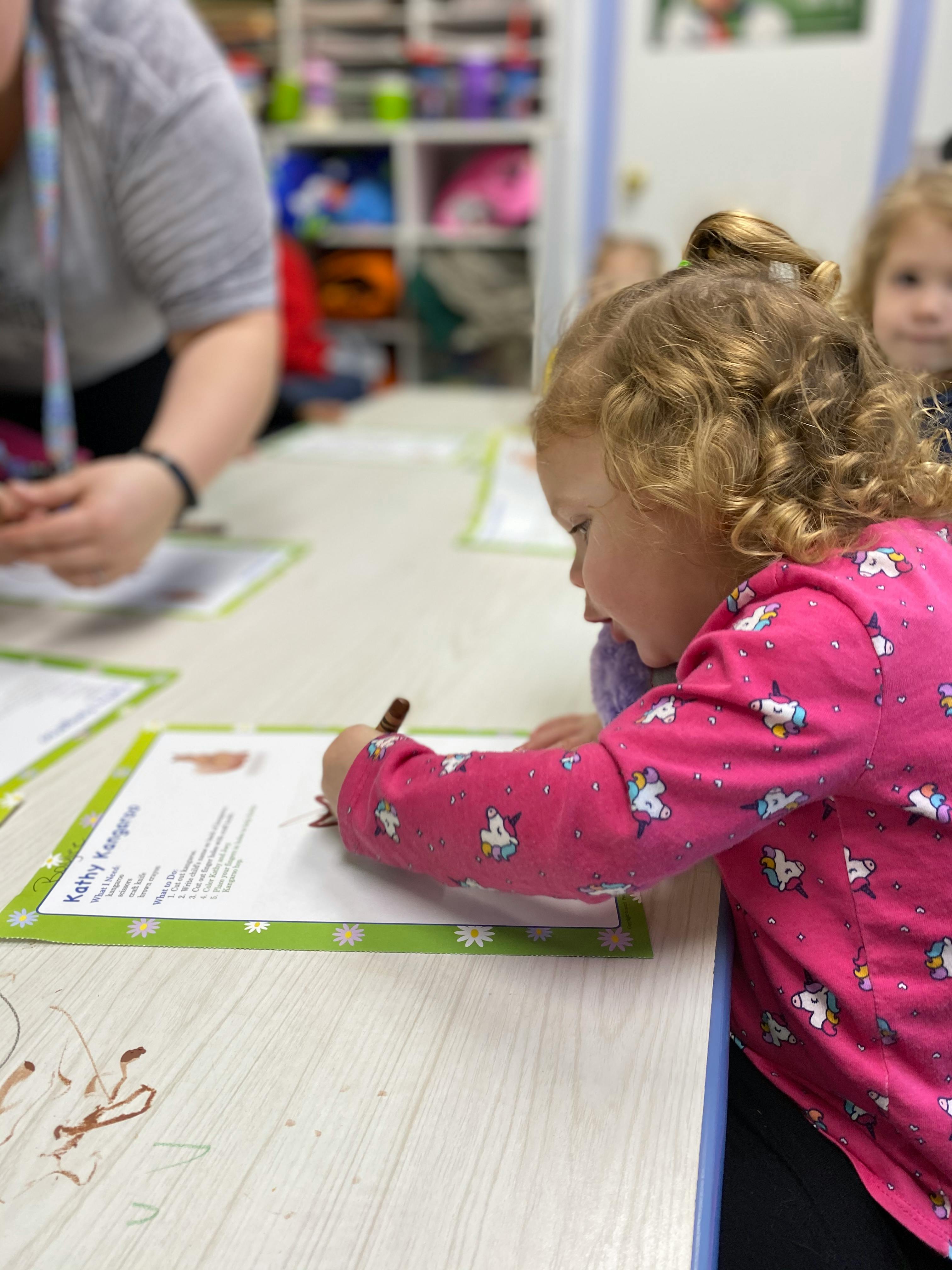 Child drawing on paper at a table