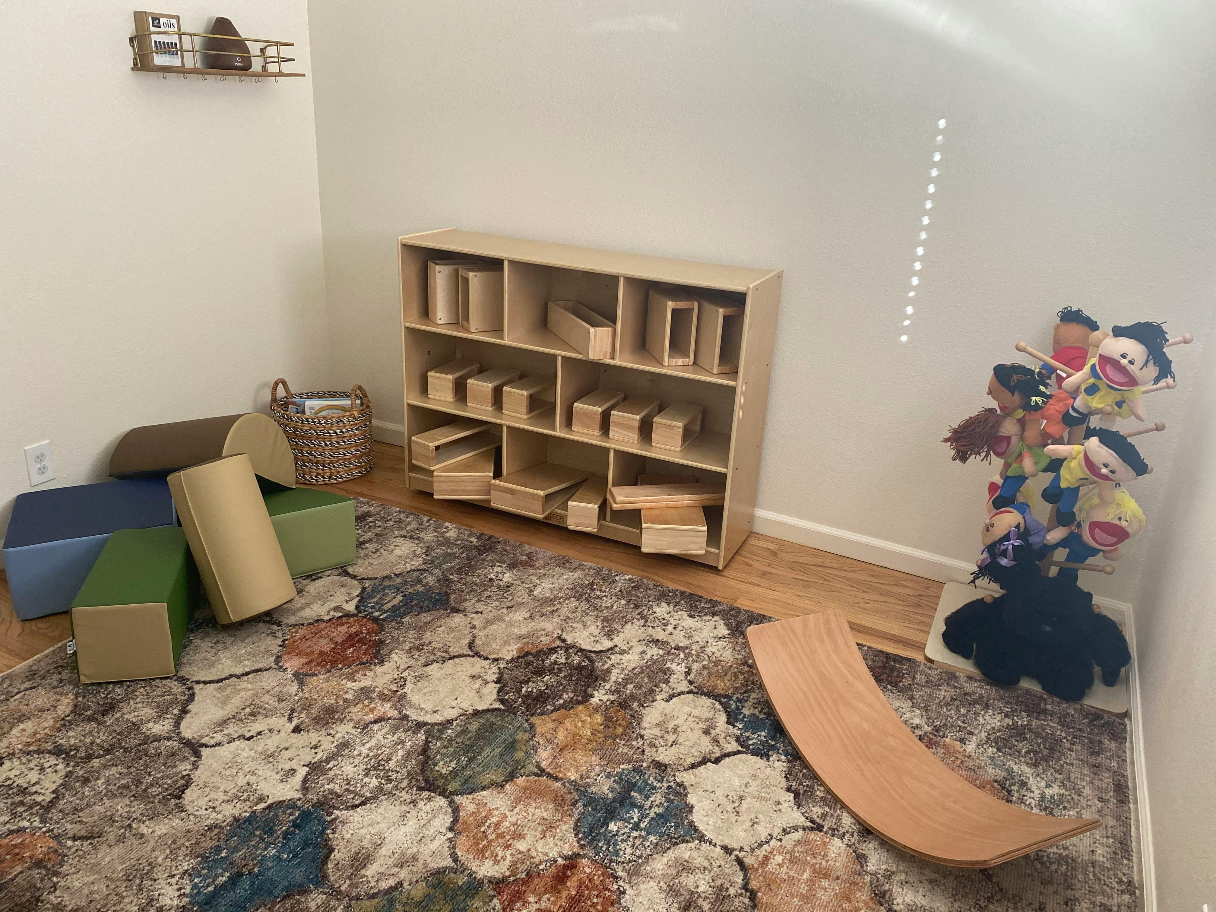 Playroom with wooden blocks, soft play shapes, and puppets