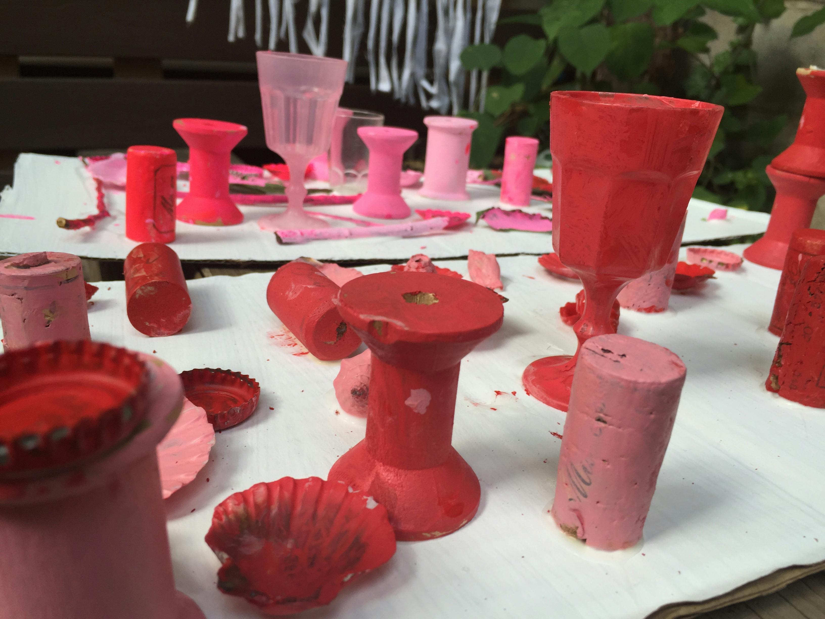 Various objects painted red and pink on a white surface