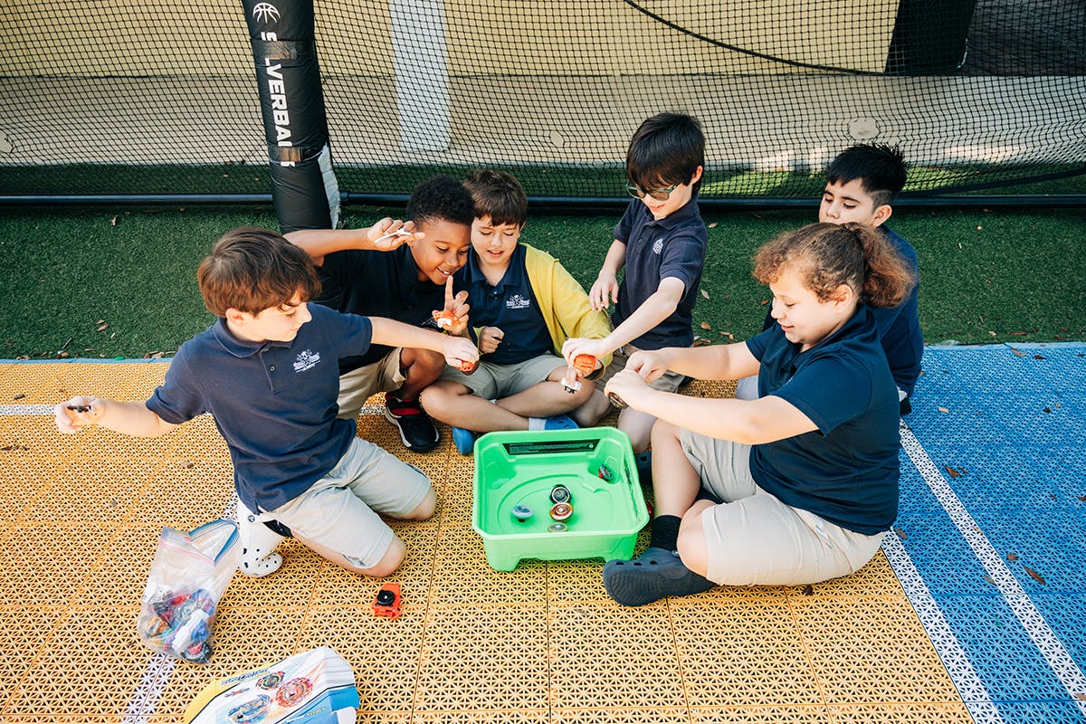 Group of children playing with spinning tops on a mat